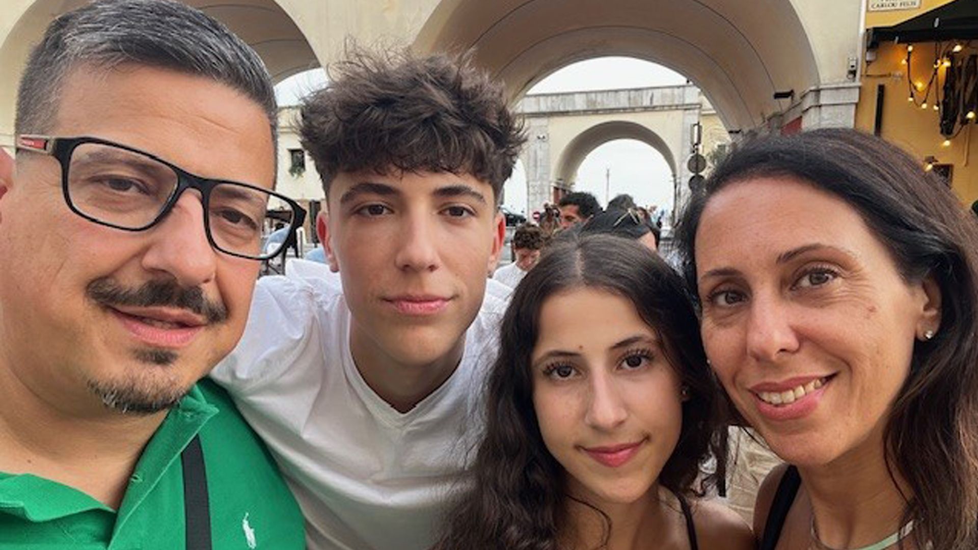 A family of four poses for a selfie while enjoying a vacation