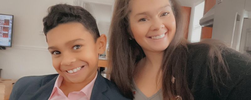 Mother and son smiling, leaning in together for a selfie