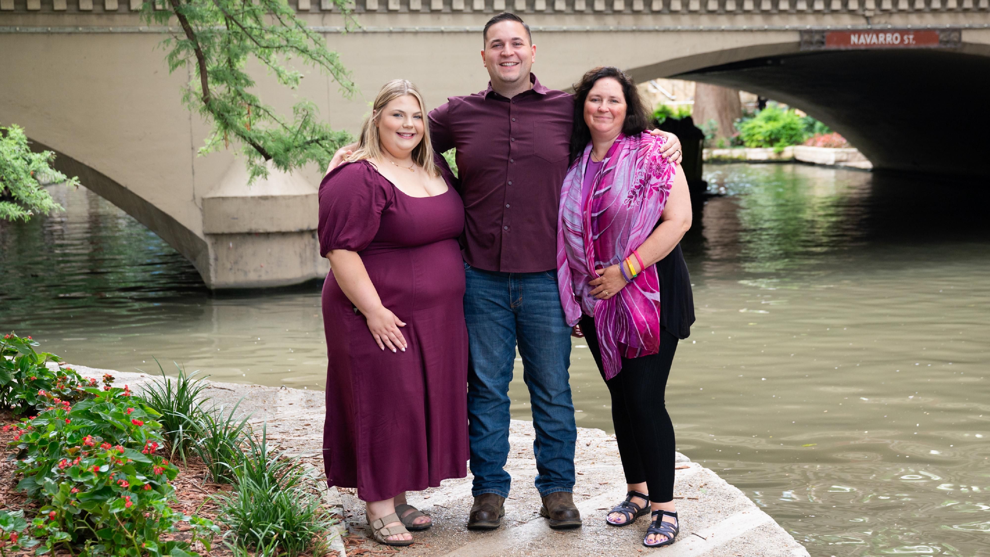 John is standing with his wife and mother