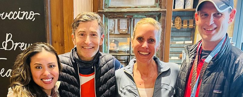 Four Sanofi Transplant Team employees wearing marathon medals and race bibs stand together smiling in a restaurant after completing the 2026 NYC Half Marathon, celebrating their fundraising effort for the National Kidney Foundation.