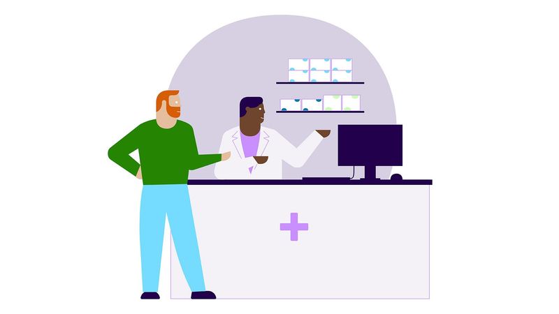 Patient at pharmacy counter speaking to pharmacist about prescribed medicines.