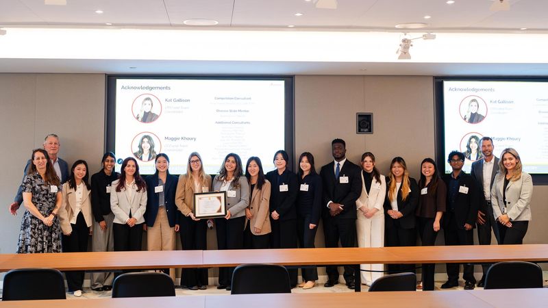 Pharmacy students and Sanofi representatives celebrate at the IPhO VIP Case Competition awards ceremony, standing together as an Acknowledgements slide honoring the competition's organizers plays on screen.