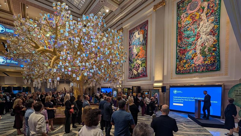 Patient advocacy leaders and Sanofi team members gather beneath the Tree of Generations sculpture at the Milken Institute Patient Advocacy Forum in Washington, D.C.