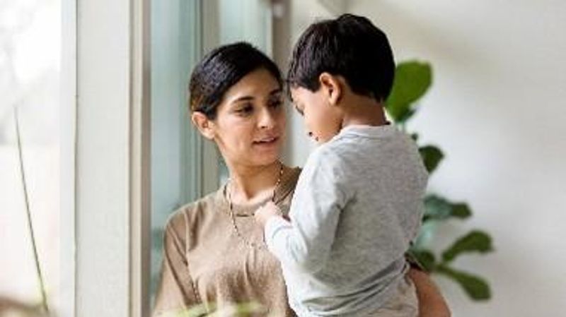 A woman and young child connect over a mobile device at home, symbolizing work-life balance and family support—core values of Sanofi's veteran employment programs and career opportunities for military veterans.
