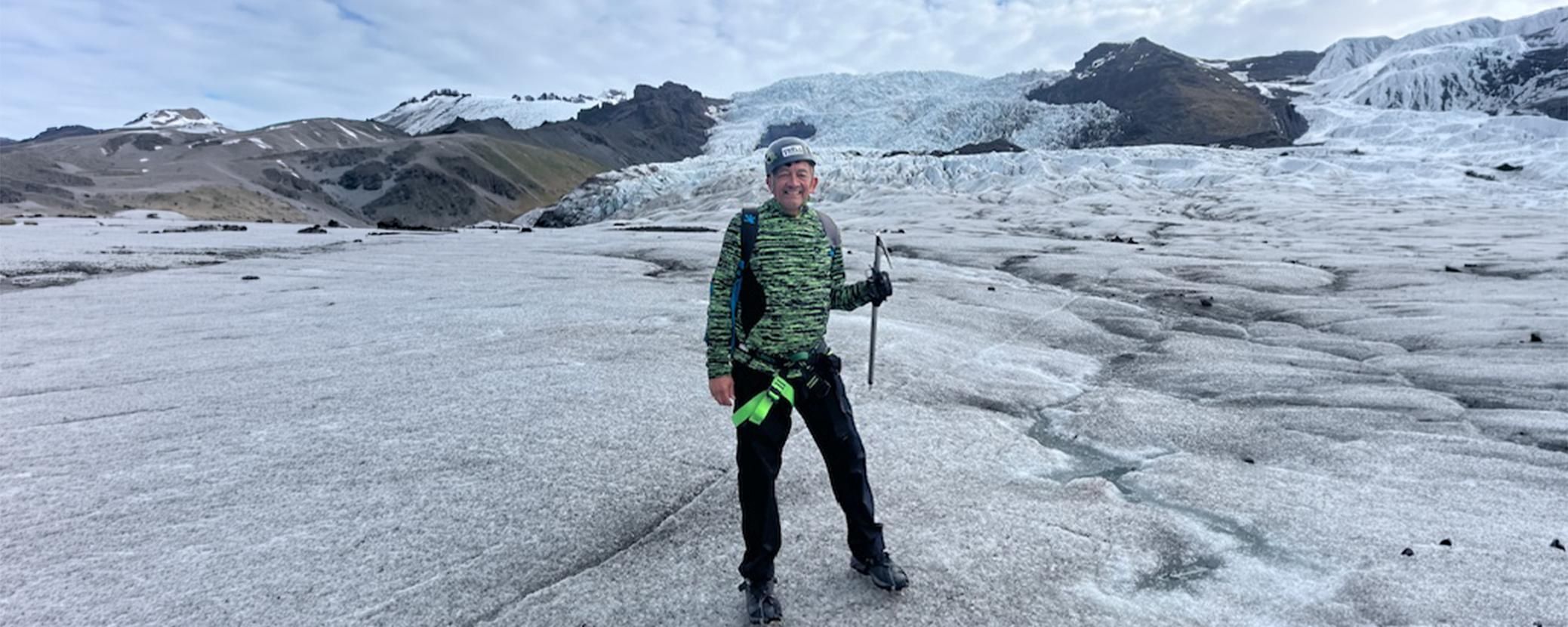 Man posing for a picture on a cloudy glacier hike in Iceland