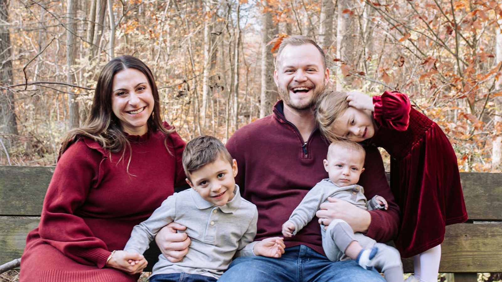 A mother and father smile with their three children.