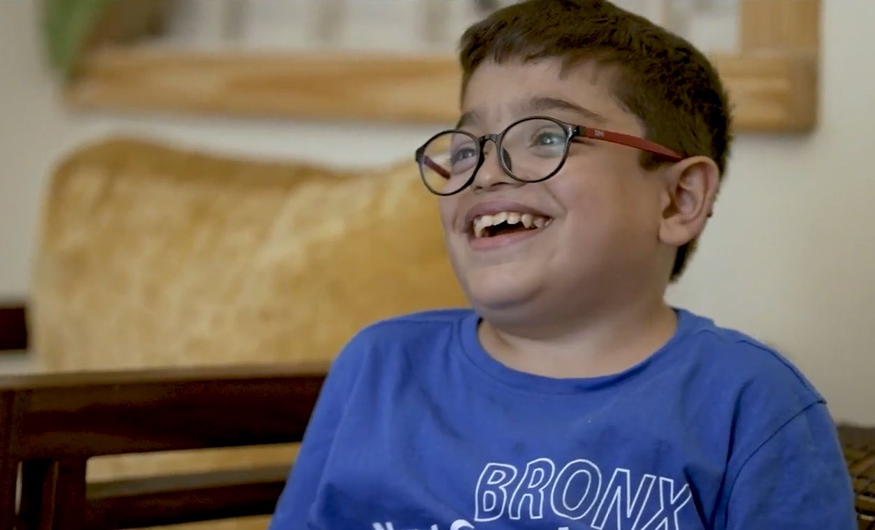 Taran, an ASMD patient, smiles at someone off camera