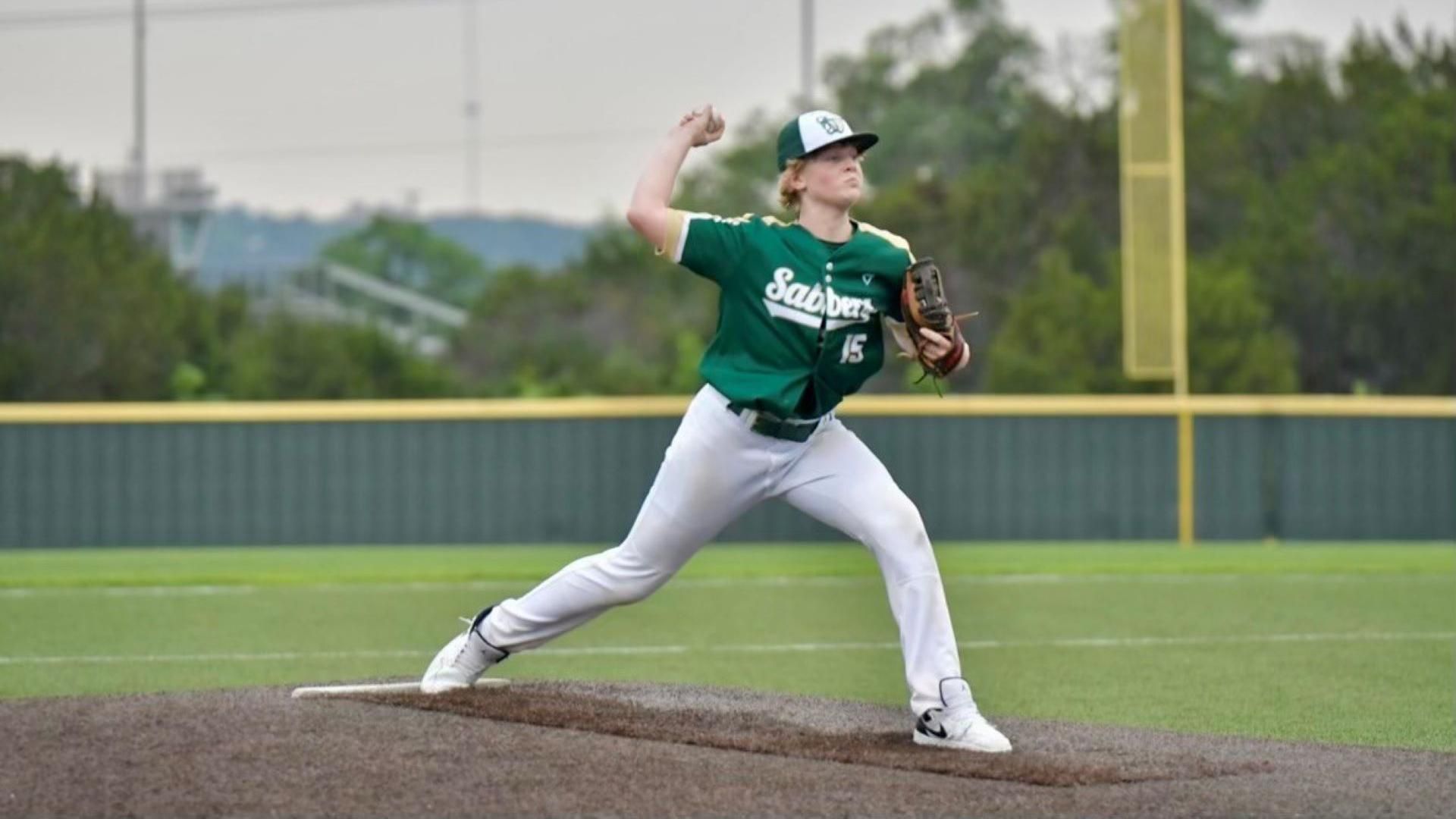 Teenage male in action on a baseball pitching mound, about to throw a ball.