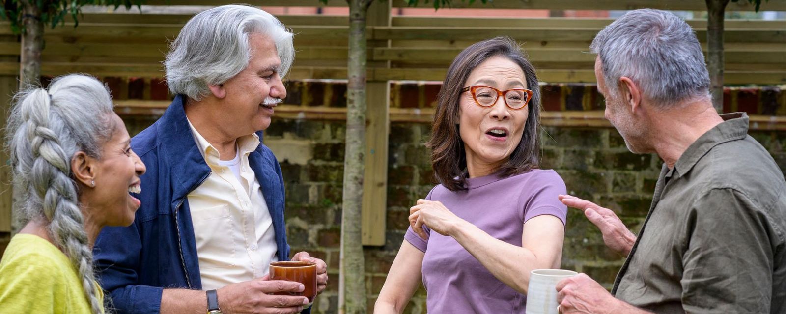 Active older adults socializing outdoors — group of seniors enjoying conversation, representing healthy aging and flu prevention awareness.