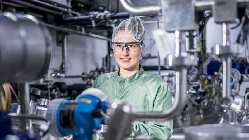 Julia Schwendner, dressed in personal protective equipment, works on the manufacturing floor.