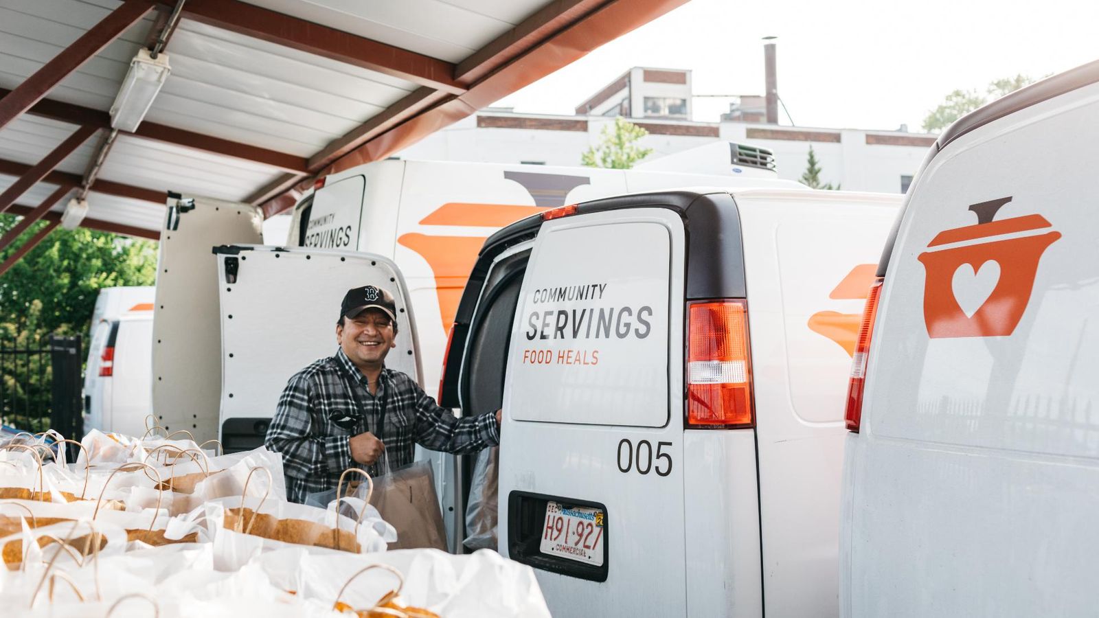 A person loads medically tailored meals into a Community Servings delivery van for the Food Is Medicine program.