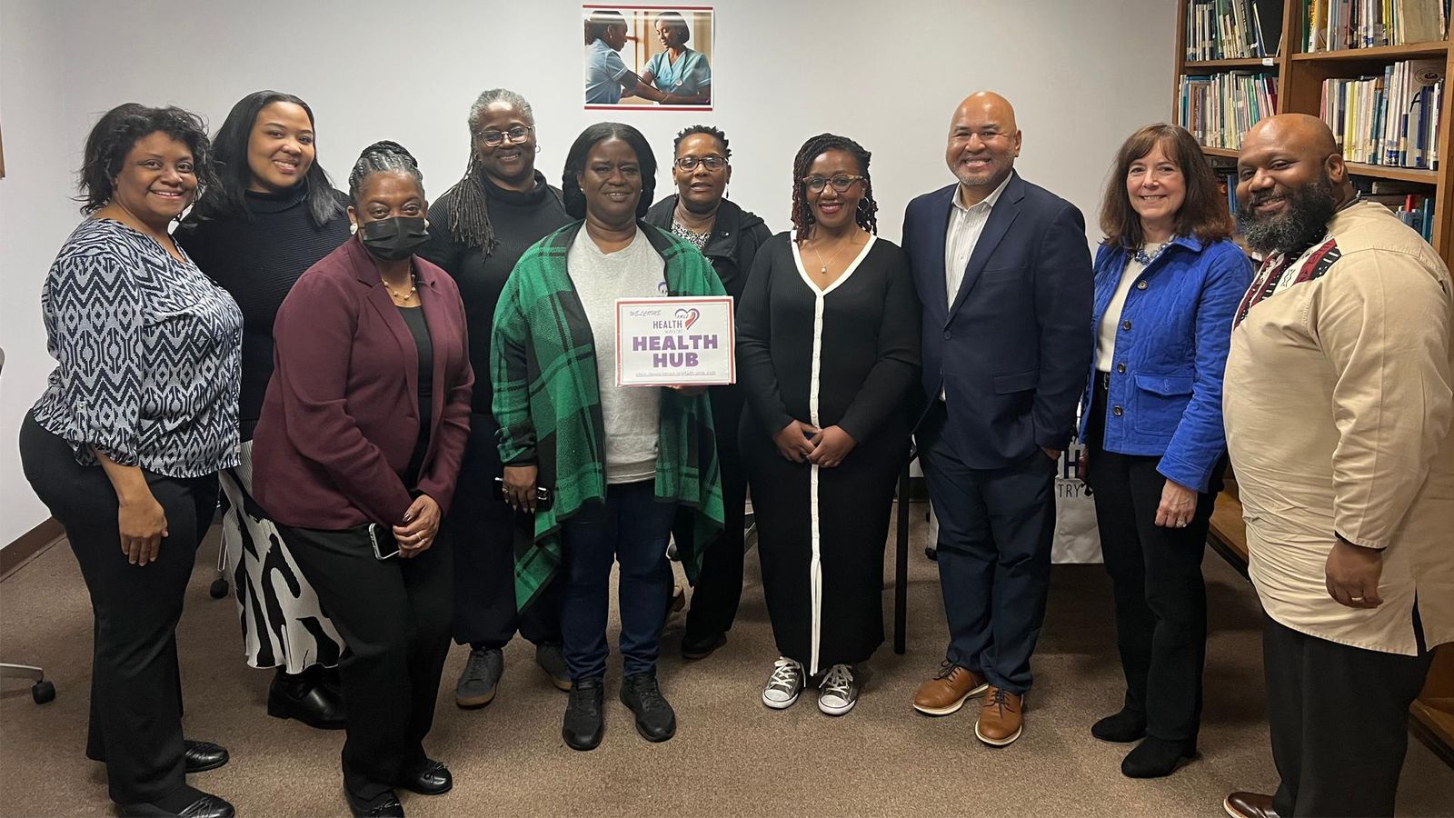 Two Sanofi employees visit H.E.A.L.U.S. Project Health Hub in Atlanta, Georgia, joining eight A.M.E. Zion Church Health Ministry members. Group poses with "Welcome to Health Hub" sign, celebrating Sanofi’s A Million Conversations community health partnership.