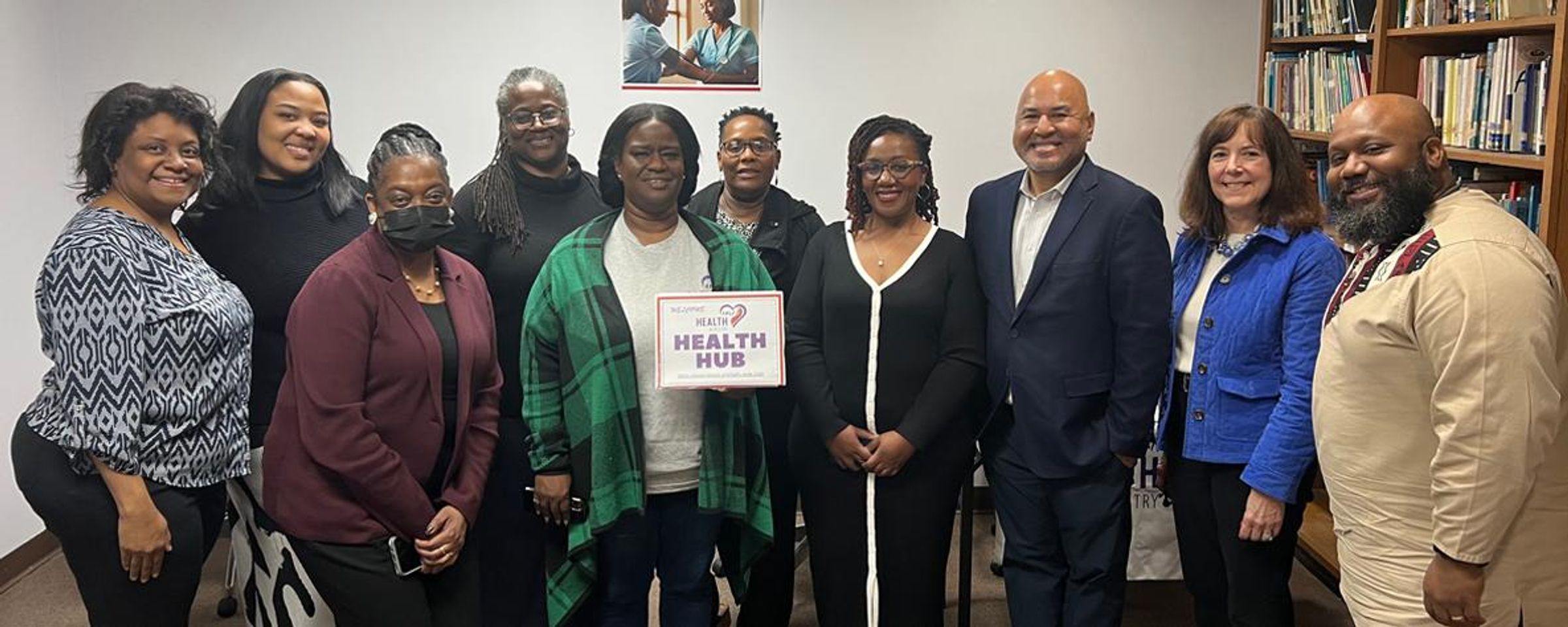Two Sanofi employees visit H.E.A.L.U.S. Project Health Hub in Atlanta, Georgia, joining eight A.M.E. Zion Church Health Ministry members. Group poses with "Welcome to Health Hub" sign, celebrating Sanofi’s A Million Conversations community health partnership.