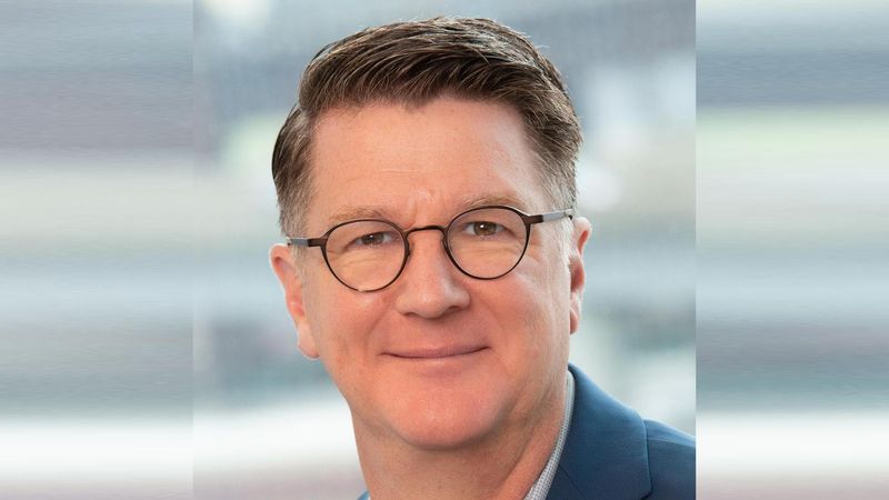 headshot of a man with black glasses