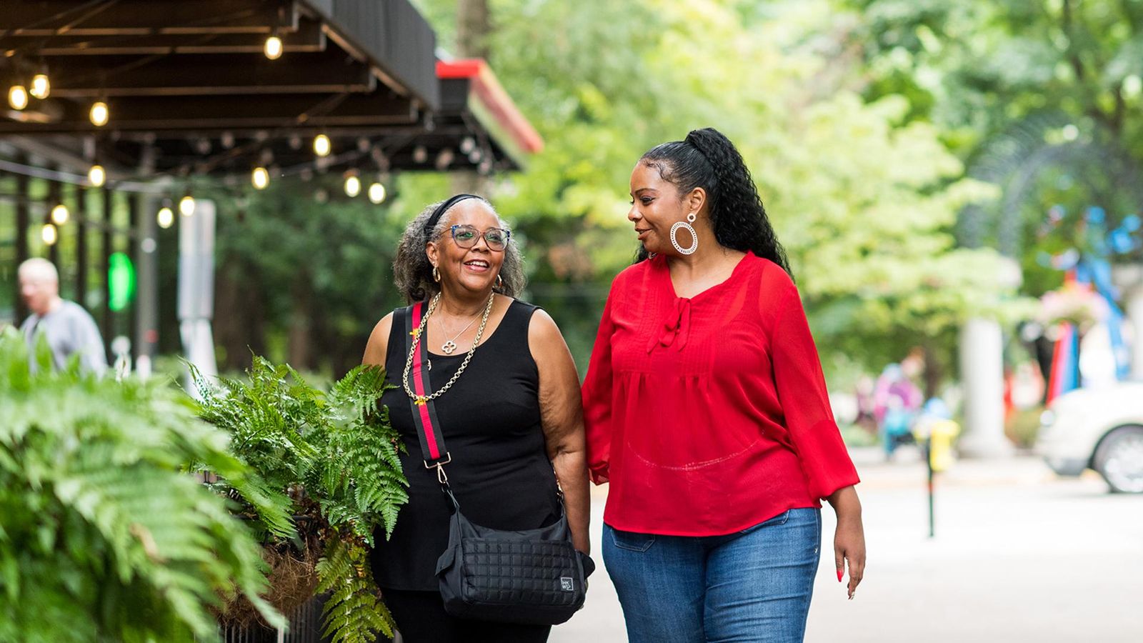 Two African-American women walking in an outdoor market.